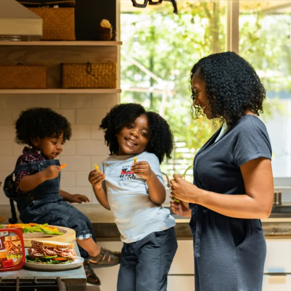 Mother and two children preparing food together in the kitchen