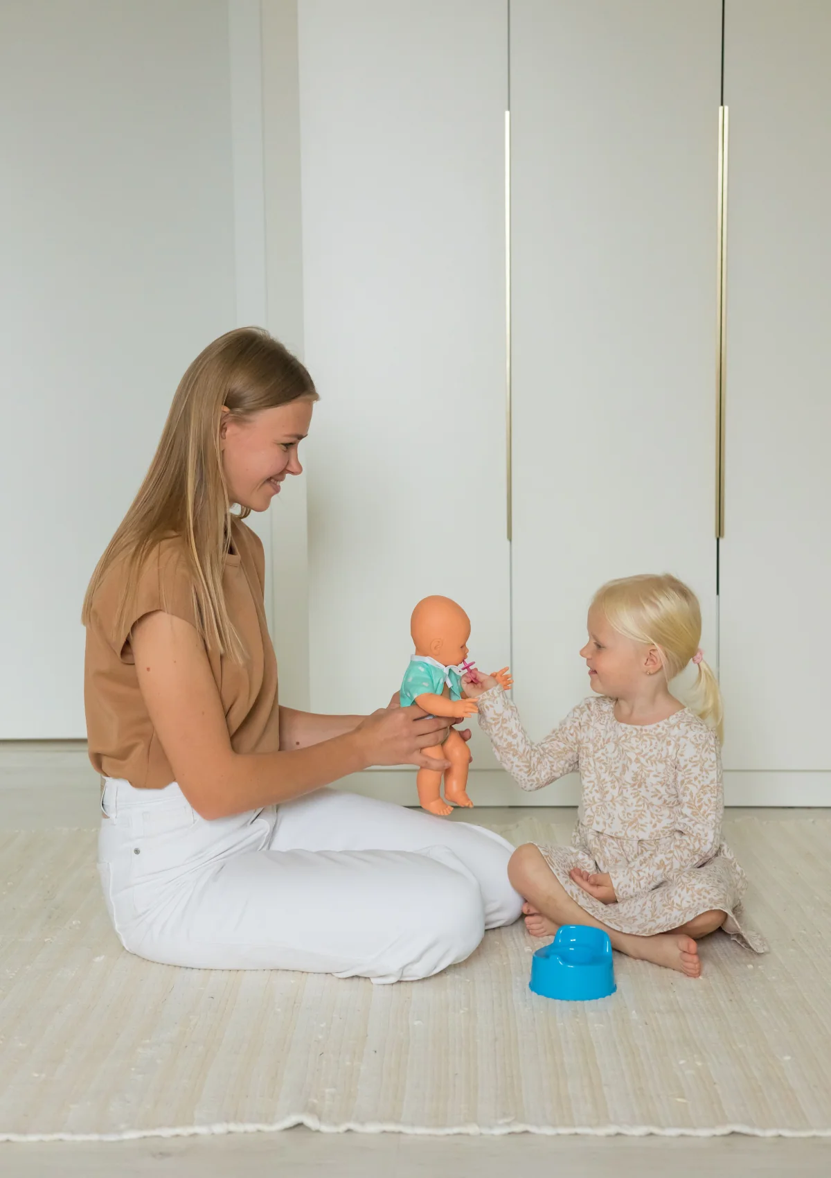Mother and daughter practicing potty routines with a doll
