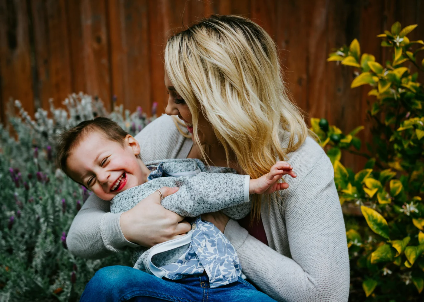 Parent holding a laughing child outdoors